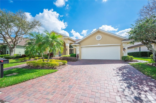 view of front facade featuring an attached garage, decorative driveway, and stucco siding