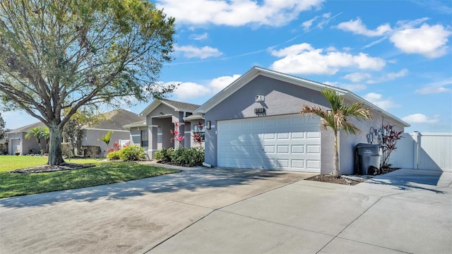 single story home with an attached garage, driveway, a front lawn, and stucco siding