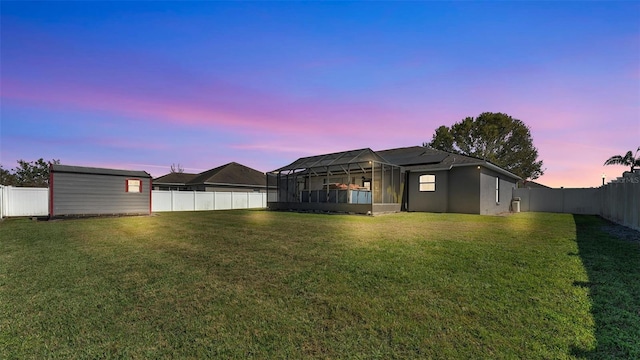 exterior space featuring a lanai, a fenced backyard, and an outdoor structure