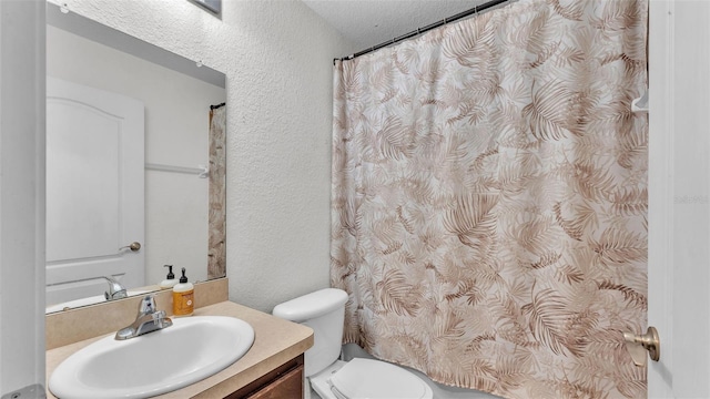 full bathroom featuring a shower with curtain, a textured wall, vanity, and toilet