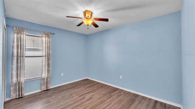 spare room with ceiling fan, a textured ceiling, baseboards, and wood finished floors