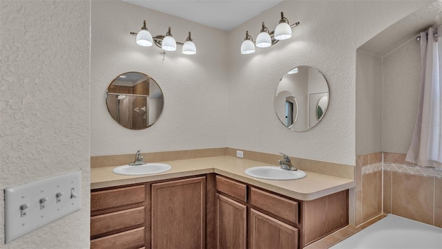 bathroom featuring a bath, a sink, and a textured wall