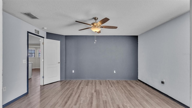 spare room with visible vents, ceiling fan, a textured ceiling, and wood finished floors