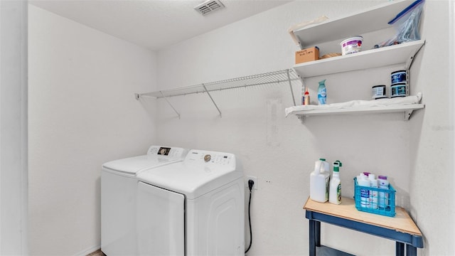 washroom featuring laundry area, visible vents, and washer and clothes dryer