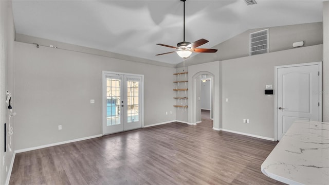 unfurnished living room featuring baseboards, visible vents, wood finished floors, vaulted ceiling, and french doors