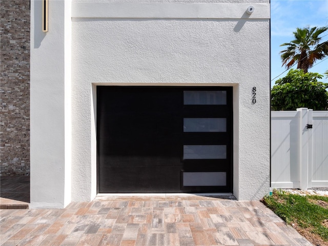 exterior space with fence, a gate, and stucco siding