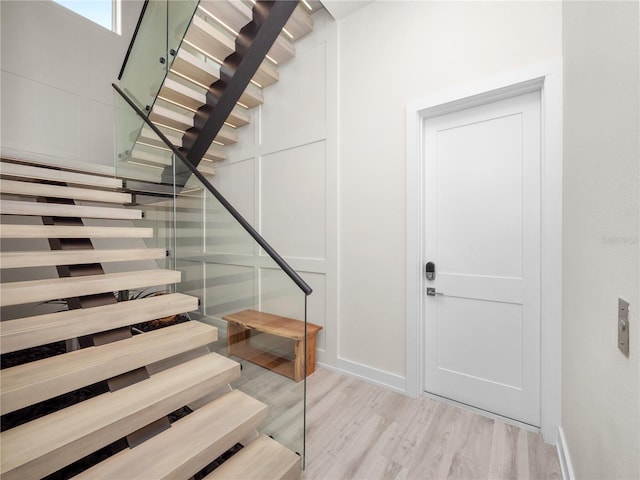 stairs with baseboards and wood finished floors