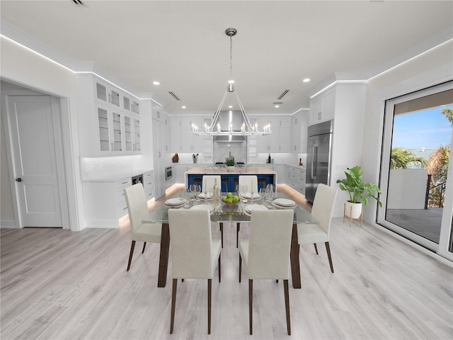 dining space featuring baseboards, recessed lighting, light wood-type flooring, and a notable chandelier