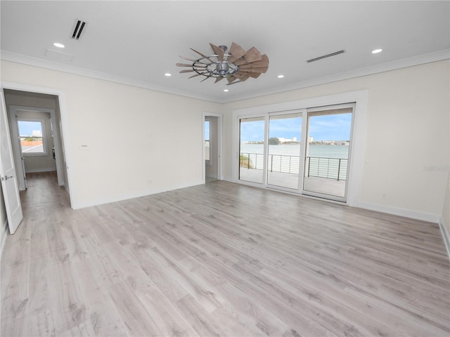 unfurnished room with visible vents, a wealth of natural light, and ornamental molding