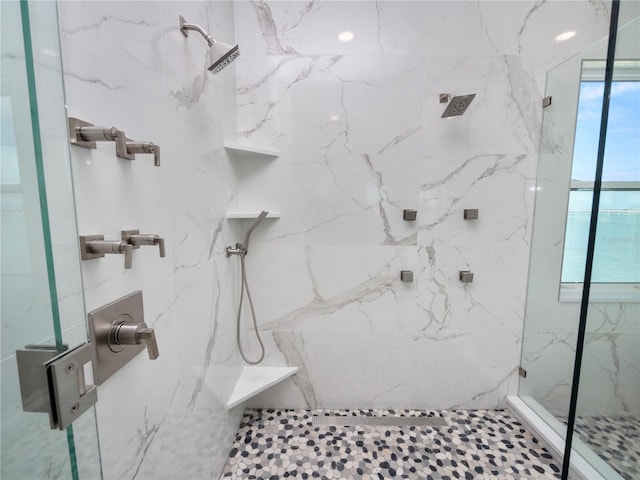 full bathroom with a marble finish shower and a wealth of natural light
