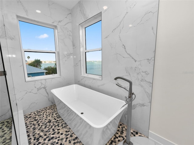 full bathroom with a shower and a freestanding bath