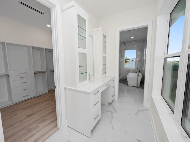 walk in closet with marble finish floor and visible vents