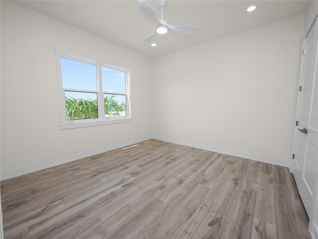 spare room with a ceiling fan, recessed lighting, light wood finished floors, and baseboards