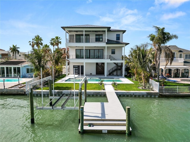 back of house with a patio, a balcony, stairway, a water view, and a standing seam roof