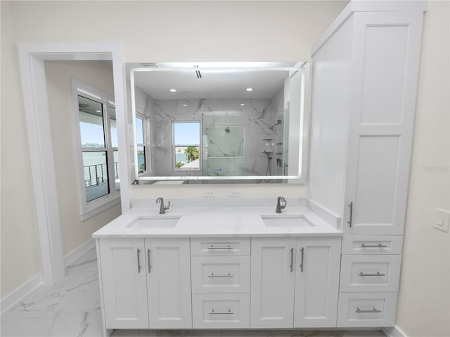 full bathroom featuring marble finish floor, a marble finish shower, baseboards, and a sink