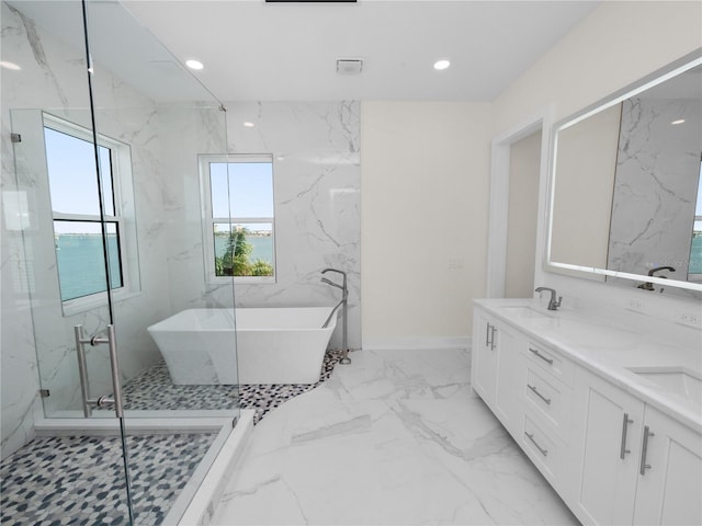 bathroom with marble finish floor, a freestanding bath, a shower stall, a sink, and recessed lighting