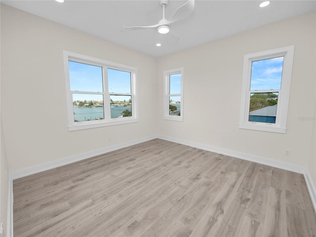 spare room featuring light wood-type flooring, ceiling fan, baseboards, and recessed lighting