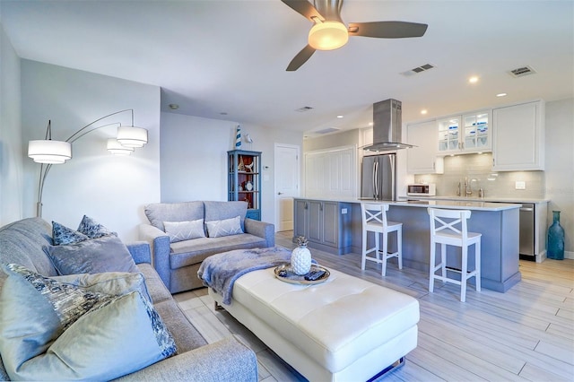 living area with recessed lighting, light wood-style floors, visible vents, and ceiling fan