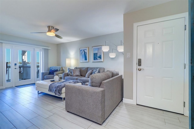 living room with a ceiling fan and baseboards