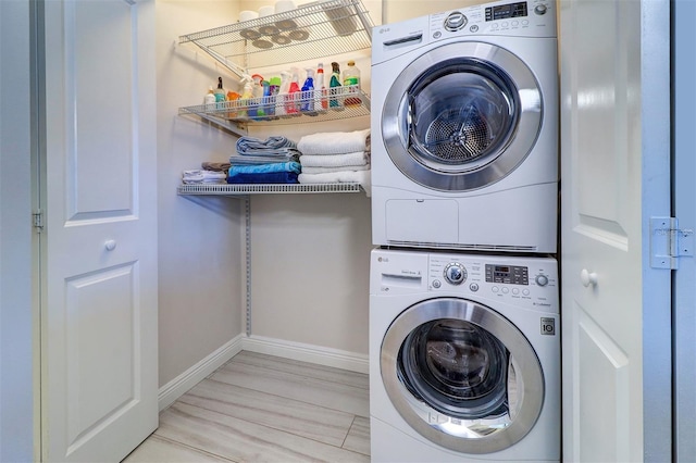 laundry room with laundry area, stacked washer / drying machine, and baseboards