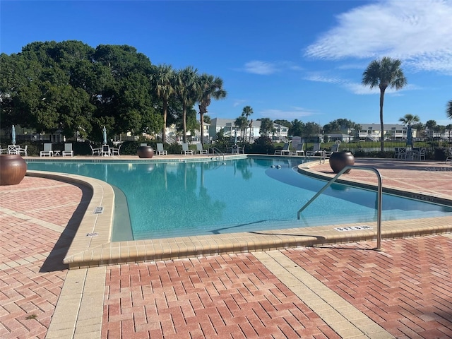 pool with a patio area and fence