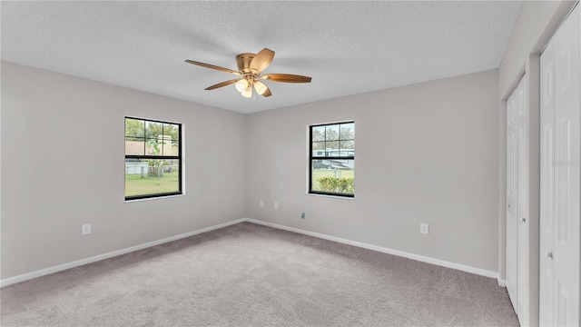 unfurnished bedroom with carpet, a closet, multiple windows, and baseboards