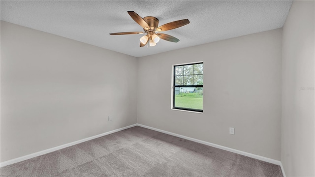 spare room featuring a ceiling fan, baseboards, a textured ceiling, and light colored carpet