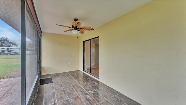 unfurnished sunroom featuring ceiling fan