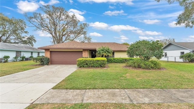 single story home featuring driveway, an attached garage, fence, a front yard, and brick siding