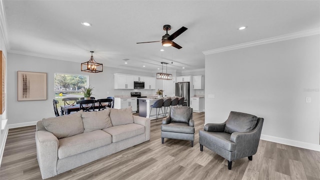 living room featuring light wood-type flooring, crown molding, baseboards, and recessed lighting