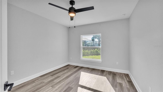 spare room featuring a ceiling fan, baseboards, and wood finished floors