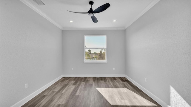 spare room with ornamental molding, dark wood-type flooring, visible vents, and baseboards