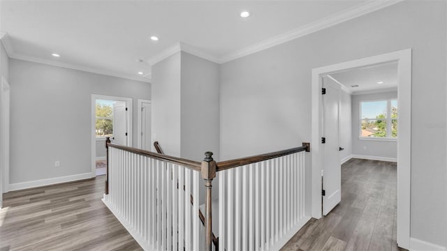 hallway with baseboards, wood finished floors, and an upstairs landing