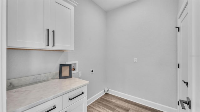 laundry room with cabinet space, baseboards, hookup for a washing machine, hookup for an electric dryer, and light wood-type flooring