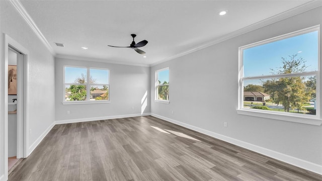 empty room with recessed lighting, wood finished floors, a ceiling fan, baseboards, and crown molding