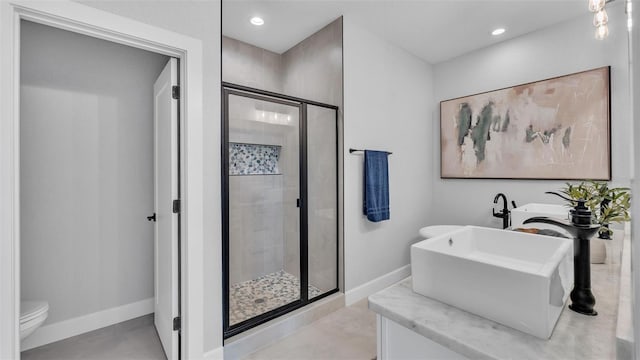 bathroom with toilet, a shower stall, baseboards, and recessed lighting