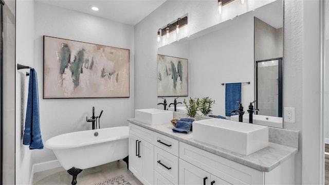 bathroom with double vanity, a freestanding tub, a sink, and a shower with shower door