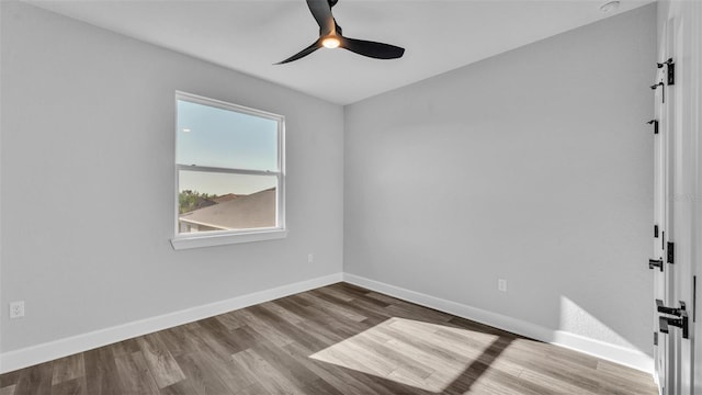 empty room with a ceiling fan, baseboards, and wood finished floors