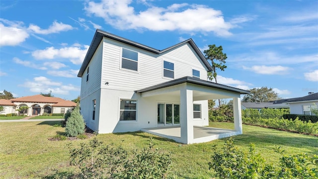 back of house with a patio, a lawn, and stucco siding