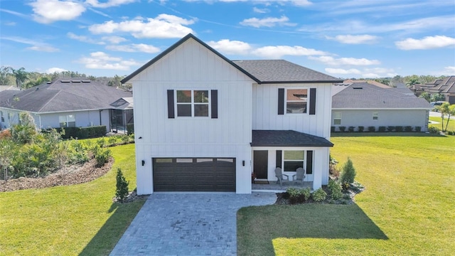 modern inspired farmhouse with a garage, a shingled roof, a front lawn, and decorative driveway