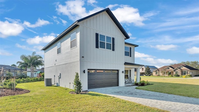 view of front of property featuring decorative driveway, central air condition unit, board and batten siding, a front yard, and a garage