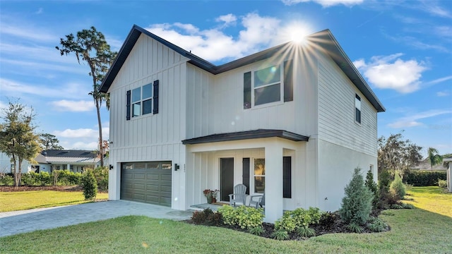 view of front of home featuring decorative driveway, a porch, board and batten siding, a garage, and a front lawn