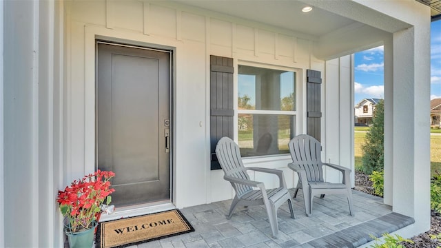 view of exterior entry featuring covered porch