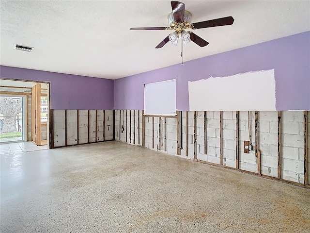 spare room with ceiling fan, visible vents, and speckled floor