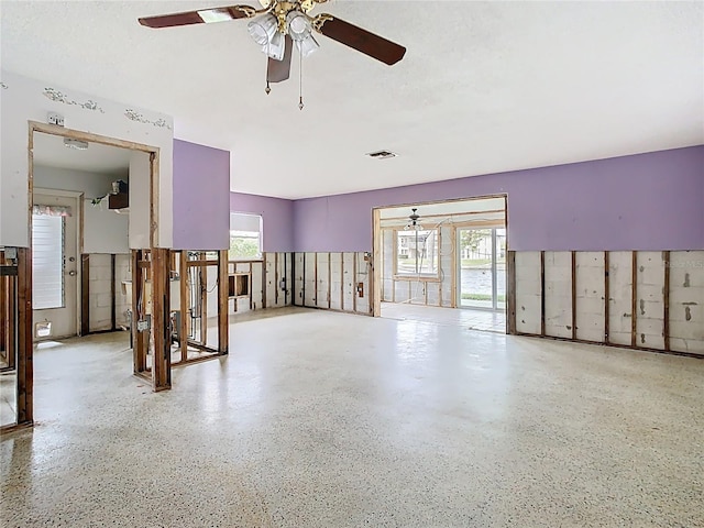 empty room with speckled floor, a textured ceiling, and visible vents