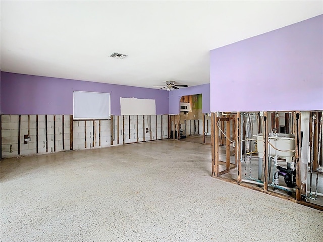 misc room featuring speckled floor, a ceiling fan, and visible vents