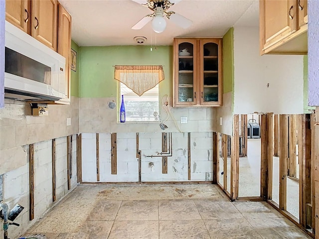 kitchen with white microwave, glass insert cabinets, and ceiling fan