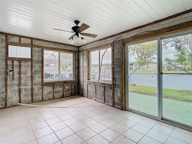 unfurnished sunroom with a ceiling fan and a water view