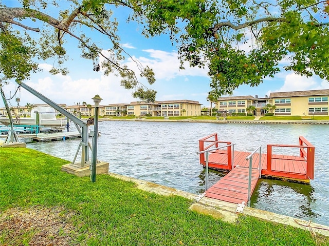 view of dock featuring a residential view, a lawn, and a water view