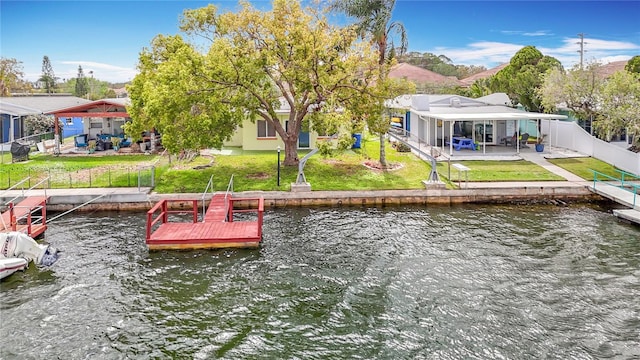 dock area with a patio, a yard, a fenced backyard, a water view, and a residential view